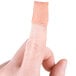 A close-up of a finger with a Medique woven fingertip bandage on it.