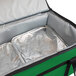 A Sterno Kelly green insulated food carrier bag with a silver tray inside.