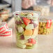 A Choice translucent plastic deli container filled with fruit salad.