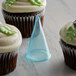 A clear plastic cone with a green leaf cupcake.