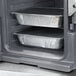 A Cambro granite gray front loading insulated food pan carrier holding metal food trays.