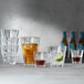 A group of Spiegelau Perfect Serve glasses filled with various drinks on a table.