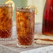Two Acopa Evora highball glasses of iced tea with lemon slices.