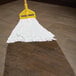 A Rubbermaid White Disposable Wet Mop Head with a yellow handle.