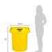 A woman standing next to a yellow Rubbermaid BRUTE 55 gallon trash can.