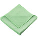 A folded green Unger SmartColor microfiber cloth.