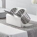 A Steril-Sil stainless steel flatware holder with perforated stainless steel cylinders holding utensils.