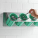 Steril-Sil stainless steel flatware organizer with green perforated plastic cylinders holding spoons.