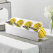 A Steril-Sil stainless steel flatware organizer with yellow perforated plastic cylinders holding spoons.