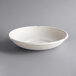 A white bowl with a rim on a gray surface.