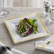 A plate of salad with greens and gold bands on a Visions white plastic plate.