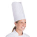 A woman wearing a white Royal Paper disposable chef hat.
