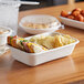 A white Eco-Products compostable takeout container with a sandwich inside.