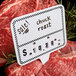 A rectangular deli sign spear with a black checkered border and the words "chuck roast" on a price tag for meat.