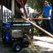 A man using a DuroMax dual fuel power generator to cut wood.