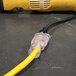 A yellow DuroMax extension power cord plugged into a yellow tube.
