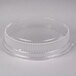A clear plastic lid for a round container with a small hole in it.