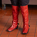 A person wearing red boots in a kitchen wearing San Jamar EZ-KLEEN® shin guards.