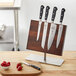 A Mercer Culinary Renaissance knife set on a wooden board with a knife.