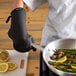 A person using a San Jamar UltiGrips oven mitt to cook asparagus in a pan.