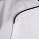 A close up of a Chef Revival white chef coat with black trim.