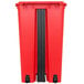 A red rectangular Continental trash can with black wheels.