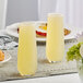 Two Libbey stemless flute glasses filled with yellow liquid on a table.