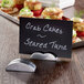 An American Metalcraft cast aluminum half moon table card holder with a sign that says crab cakes and sea tuna.