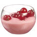 A Solia clear plastic mini dish filled with pink yogurt and red berries.