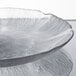 A clear glass Arcoroc Fleur dessert plate with a design on it.