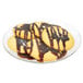 An Arcoroc Fleur glass dessert plate with cookies drizzled with chocolate sauce.