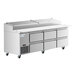 An Avantco stainless steel refrigerated pizza prep table with six drawers on wheels.