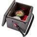A red Cambro Camwarmer inside a plastic container with food in it.