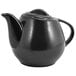 A close-up of the front of a black teapot with a black handle.