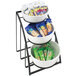 A three tiered bowl display stand with snacks and nuts in the bowls.