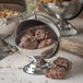 A Carlisle stainless steel bowl filled with chocolate covered nuts.