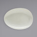 A white oval Front of the House Tides porcelain plate with a circular design.