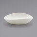 A white Front of the House Tides scallop oval bowl on a gray surface.