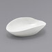 A Front of the House white oval porcelain ramekin on a gray surface.
