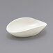 A Front of the House Tides white scallop oval ramekin on a gray surface.
