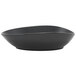 A close up of a Front of the House Tides semi-matte mussel oval porcelain bowl with a black finish.