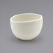 A Front of the House Tides scallop round porcelain bowl with a curved edge on a gray surface.