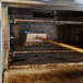 A Carlisle Sparta oven and grill brush with a wooden block in the oven.