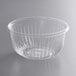 A Dart clear PET plastic bowl on a gray surface.