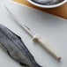 A Dexter-Russell Sani-Safe fillet knife cutting a fish.