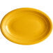 An Acopa mango orange oval stoneware platter with a rim.