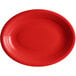 An oval red stoneware platter with a rim.