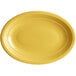 An Acopa Capri yellow oval platter with a rim on a white background.