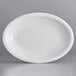 An Acopa Capri coconut white stoneware oval platter with a curved edge.