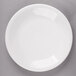 A white Fiesta® Dinnerware salad plate with a white rim on a gray surface.